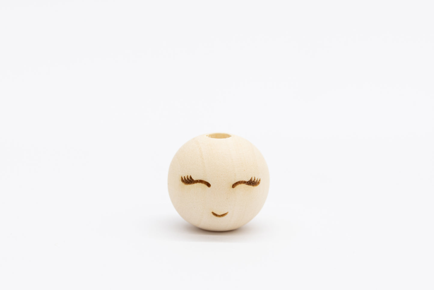 Drewniany koralik z wygrawerowaną buzią i rzęsami