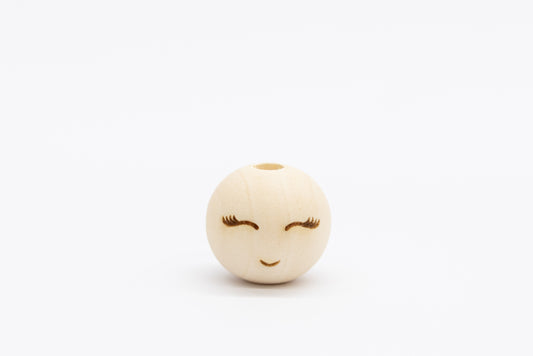 Drewniany koralik z wygrawerowaną buzią i rzęsami