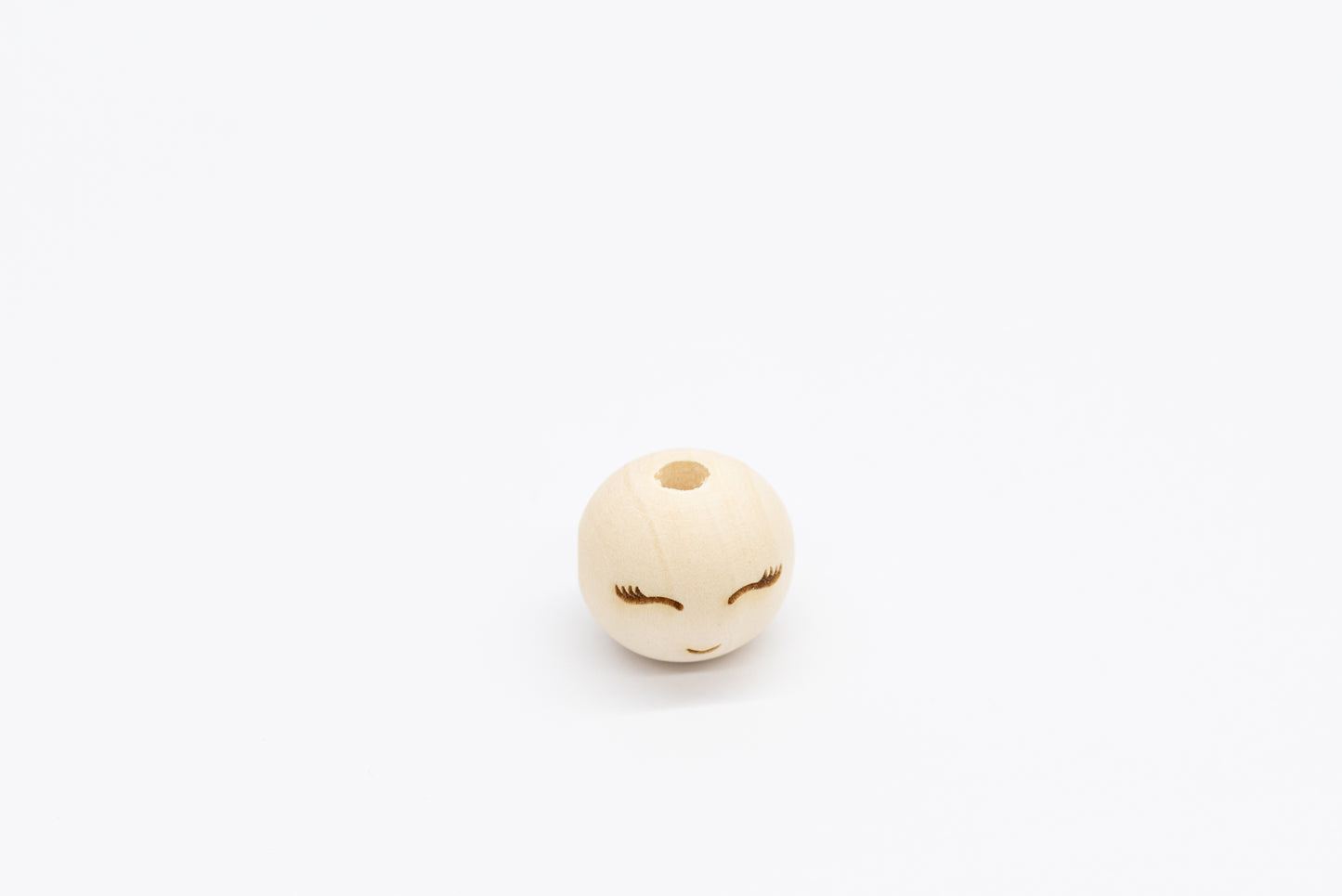 Drewniany koralik z wygrawerowaną buzią i rzęsami